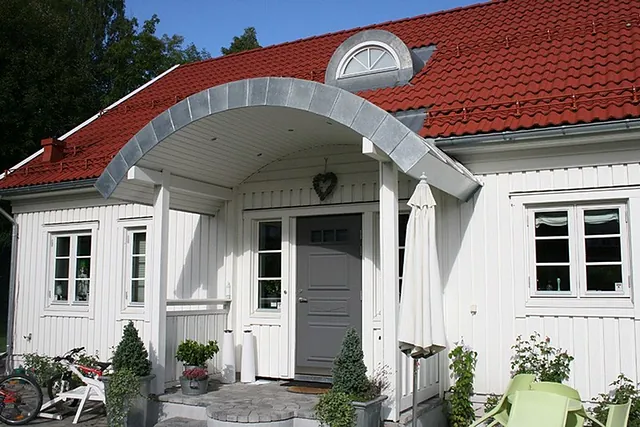 Landlig enebolig med rødt tak