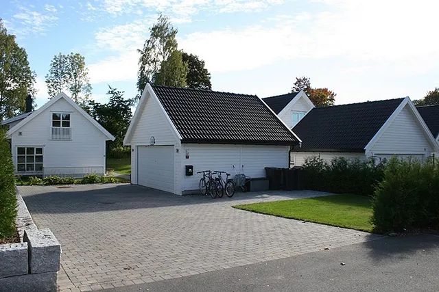 Hvitt hus i boligfelt på dagtid