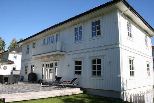 Hvit enebolig med stor platt utenfor
