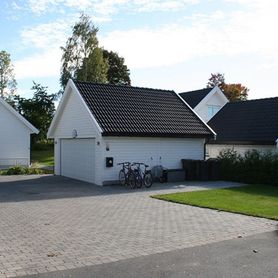 Hvitt hus i boligfelt på dagtid